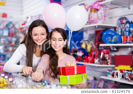 woman and satisfied daughter with gifts and balloons in the shop woman and satisfied daughter with gifts and balloons in the shop 61324579