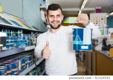 Adult man is deciding on best wall paint Adult man is deciding on best wall paint 61324591