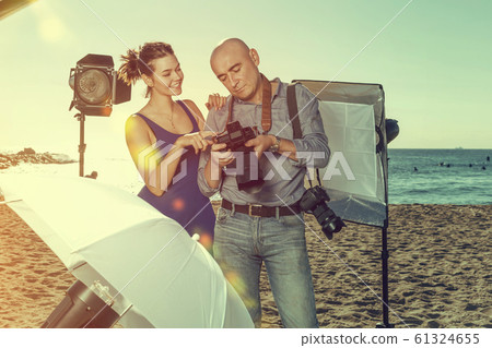 photographer showing photos to model girl during shooting photographer showing photos to model girl during shooting 61324655