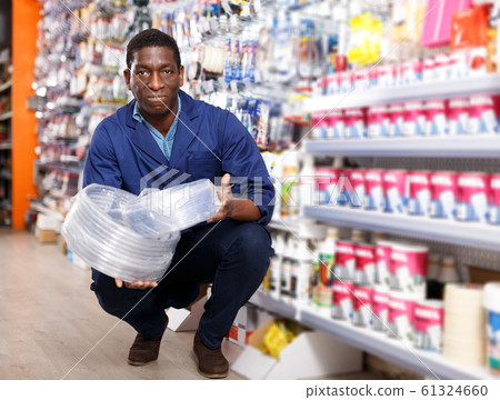 seller proffering goods in shop of household materials and tools seller proffering goods in shop of household materials and tools 61324660