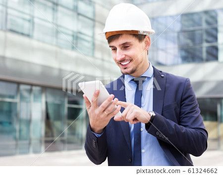 Smiling male workers outdoors with modern touchpad Smiling male workers outdoors with modern touchpad 61324662