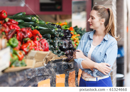 Woman is choosing fresh aubergine 61324668