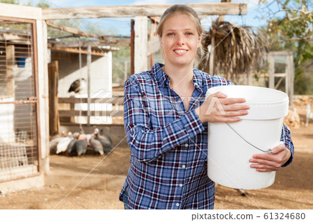 Woman feeding poultry 61324680