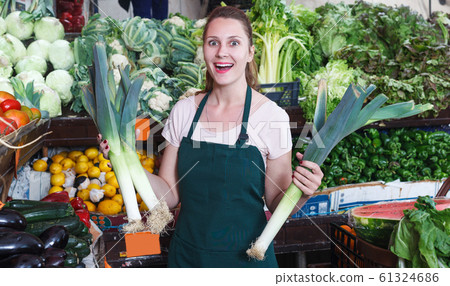 Seller female is holding green leek Seller female is holding green leek 61324686