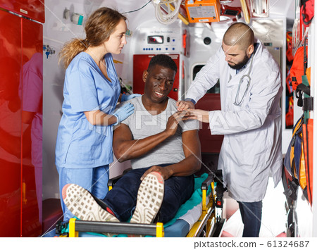 Doctors providing medical care to injured man Doctors providing medical care to injured man 61324687