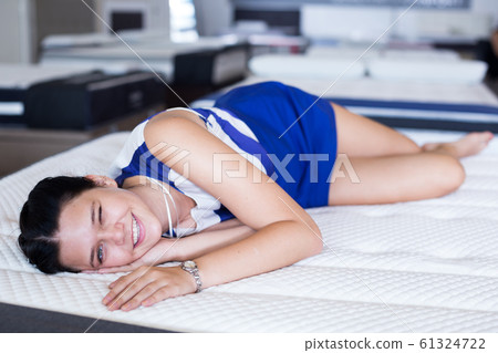 Female is lying on mattress for testing it Female is lying on mattress for testing it 61324722