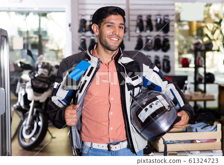 Portrait of glad man who is choosing new helmet 61324723