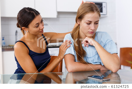 Unhappy girl friends discussion while quarrel in home interior indoors Unhappy girl friends discussion while quarrel in home interior indoors 61324725
