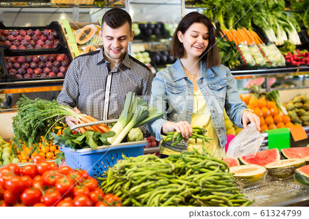 Young couple examining various vegetables Young couple examining various vegetables 61324799