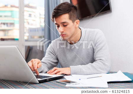 Upset young man counts family budget on laptop Upset young man counts family budget on laptop 61324815