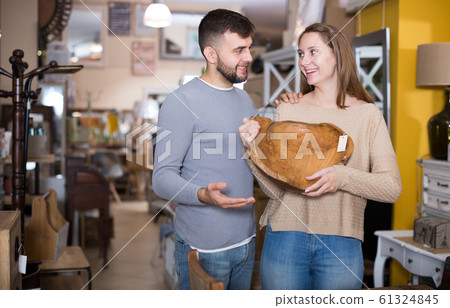 Happy couple choosing vintage wooden platter Happy couple choosing vintage wooden platter 61324845
