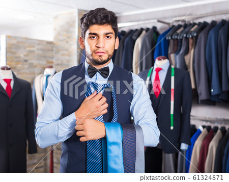 Guy is picking up tie for waistcoat Guy is picking up tie for waistcoat 61324871