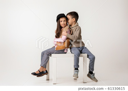 Cute stylish little couple child girl and boy sittting together . Cute stylish little couple child girl and boy sittting together . 61330615