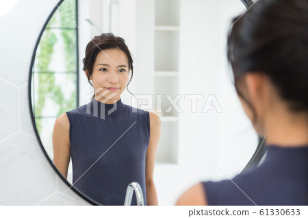 Woman moving into mirror white background Woman moving into mirror white background 61330633