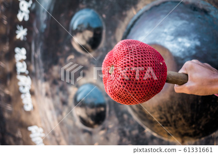 Hand hit big gong in temple 61331661