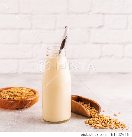 A bottle of oat milk and oats. 61332666