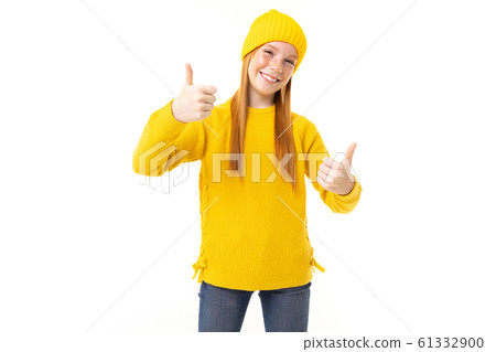 Happy teenager girl with red hair, yellow hoody and trousers shows like isolated on white background Happy teenager girl with red hair, yellow hoody and trousers shows like isolated on white background 61332900