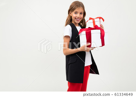 Teenager caucasian girl in black jacket, white shirt and red pants holds a white boxes with gifts Teenager caucasian girl in black jacket, white shirt and red pants holds a white boxes with gifts 61334649