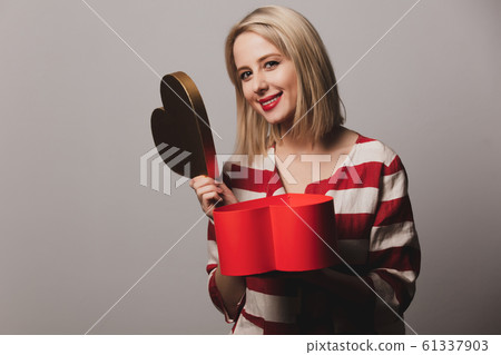 beatiful girl holds heart shape gift box 61337903