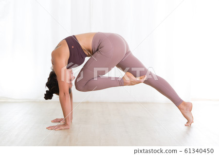 Portrait of gorgeous active sporty young woman practicing yoga in studio. Beautiful girl practice Sasangasana, rabbit yoga pose. Healthy active lifestyle, working out indoors in gym 61340450