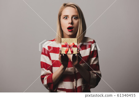 girl holds gift box on gray background girl holds gift box on gray background 61340455