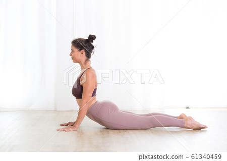 Portrait of gorgeous active sporty young woman practicing yoga in studio. Beautiful girl practice Sasangasana, rabbit yoga pose. Healthy active lifestyle, working out indoors in gym 61340459