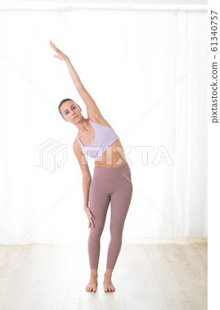 Portrait of gorgeous active sporty young woman practicing yoga in studio. Beautiful girl practice Ardha Chandrasana,half moon yoga pose. Healthy active lifestyle, working out in gym 61340757