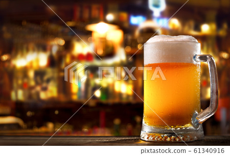 cold mug of beer in a bar on wooden table cold mug of beer in a bar on wooden table 61340916
