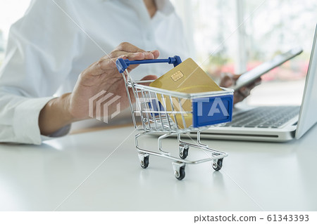Young woman holding credit card and using laptop computer. Online shopping concept. 61343393