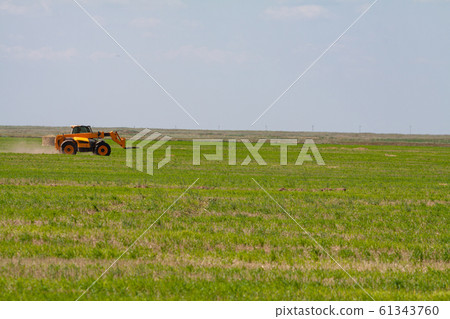 Tractor loading hay bales on truck agricultural works Tractor loading hay bales on truck agricultural works 61343760