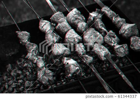 barbecue of pork is prepared on skewers on the grill 61344337