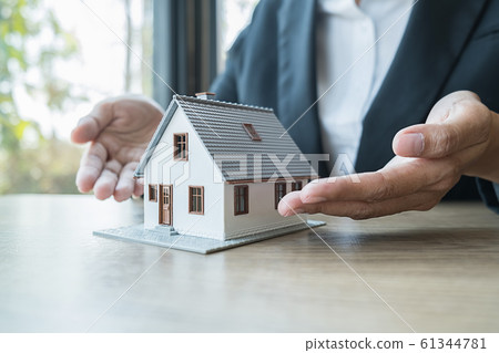House model with agent asking costumer for contract to buy, get insurance or loan real estate. 61344781