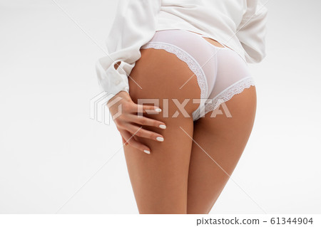 Faceless graceful woman with hands on buttock 61344904