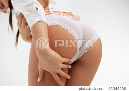 Faceless graceful woman with hands on buttock 61344908