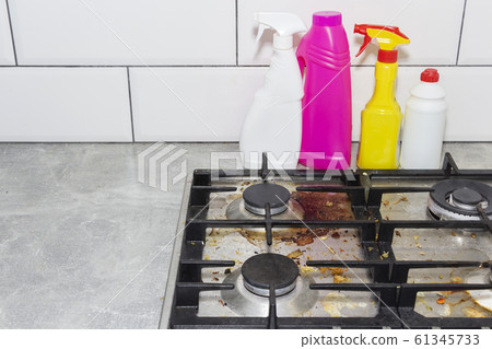 Dirty, top of the gas stove with bits of food. House cleaning. 61345733