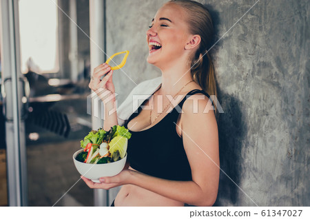 Beautiful young lady with salad in the Gym. Sport 61347027