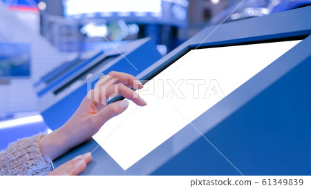 Woman touching interactive white blank touchscreen display kiosk at exhibition Woman touching interactive white blank touchscreen display kiosk at exhibition 61349839