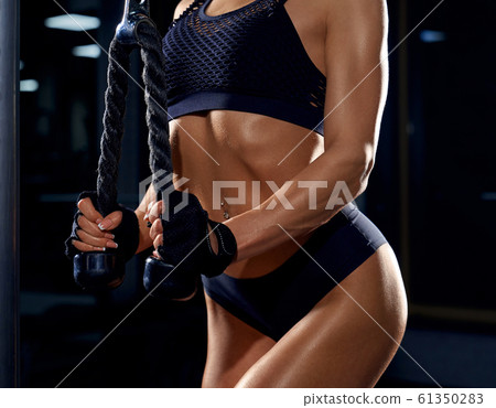 Female bodybuilder training triceps in gym. Stock Photo