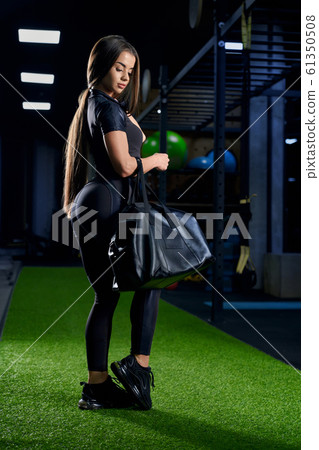 Woman posing with sport bag in gym. Woman posing with sport bag in gym. 61350508