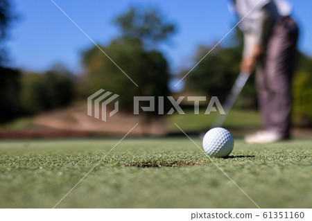 Man playing golf on a golf course. Man playing golf on a golf course. 61351160