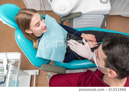 Dentist talking to a patient 61351998