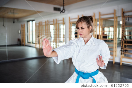 A young woman practising karate indoors in gym. 61352705