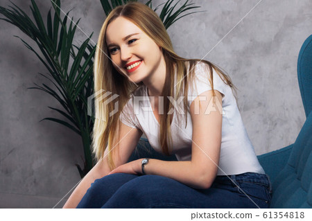 Beautiful girl in a white vest sitting Beautiful girl in a white vest sitting 61354818