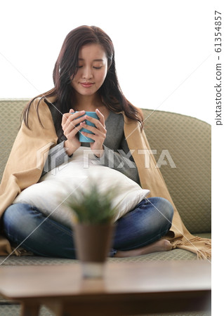 A woman drinking coffee on the sofa A woman drinking coffee on the sofa 61354857