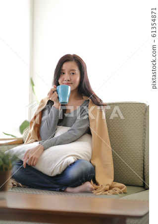 A woman drinking coffee on the sofa A woman drinking coffee on the sofa 61354871