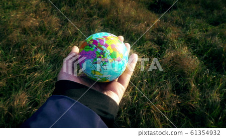 world in hand, female hand holding planet globe 61354932