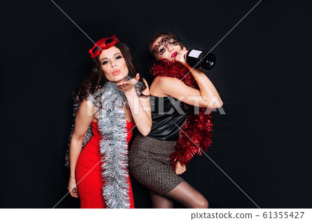 Happy smiling girls In stylish dresses with champagne celebrate at birthday party. 61355427