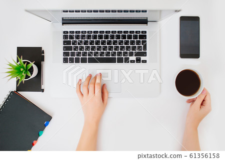Flatlay with hands typing on a keyboard of laptop. White desk. Flatlay with hands typing on a keyboard of laptop. White desk. 61356158