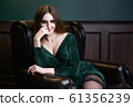 Beautiful woman with long hair sensual greed dress and stockings studio photoshoot 61356239