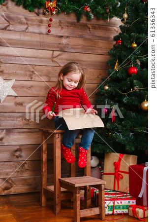 Cute small child girl writes the letter to Santa at home Cute small child girl writes the letter to Santa at home 61356343